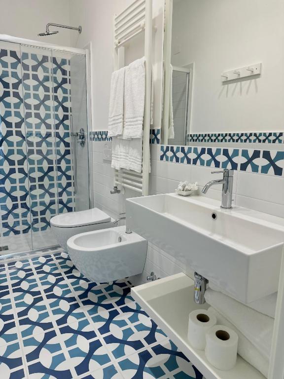 a white bathroom with a sink and a toilet at Blumare Amalfi Coast in Maiori