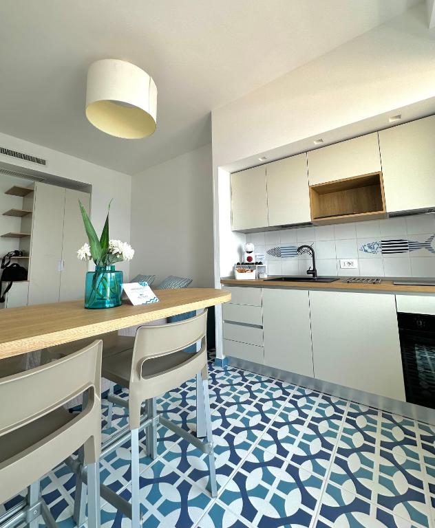 a kitchen with a table and chairs on a blue and white floor at Blumare Amalfi Coast in Maiori