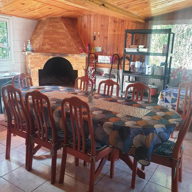 una sala da pranzo con tavolo, sedie e camino di LE VIGNERON a Cilaos