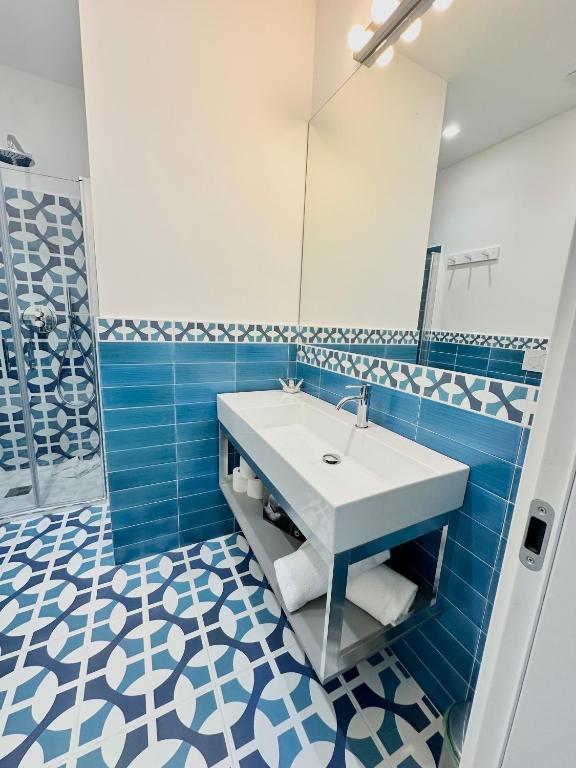 a blue and white bathroom with a sink and a mirror at Blumare Amalfi Coast in Maiori