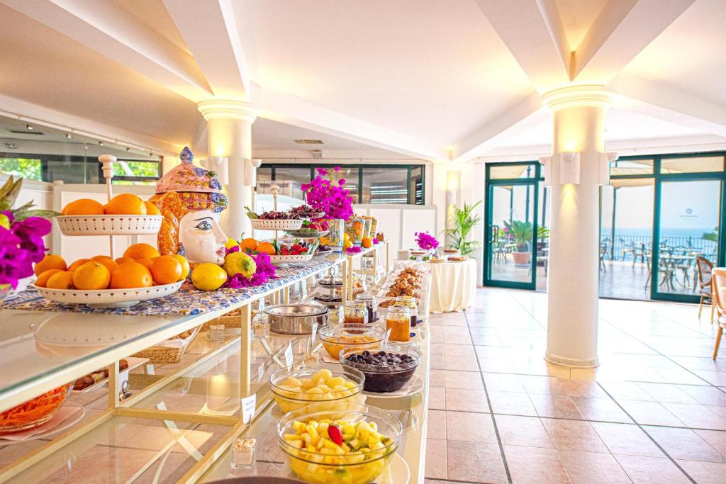 a buffet line with fruits and desserts on display at Baia Taormina - CDSHotels in Forza dʼAgro