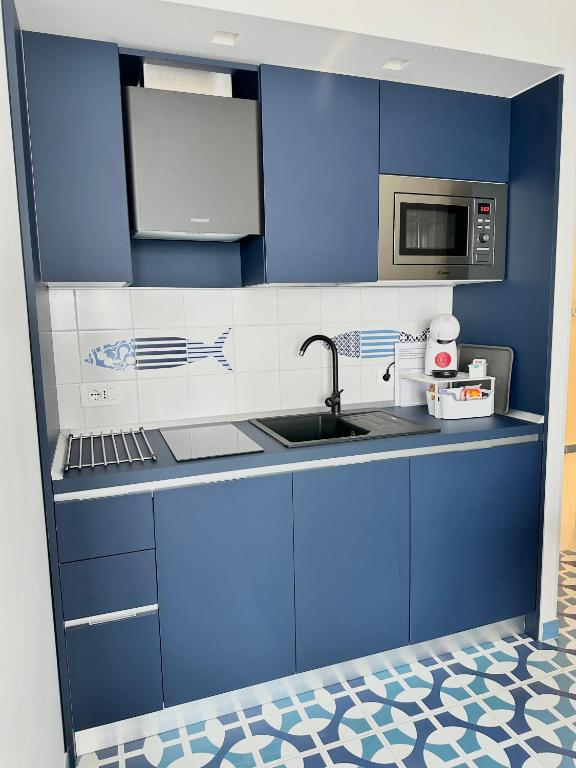 a blue kitchen with a sink and a microwave at Blumare Amalfi Coast in Maiori