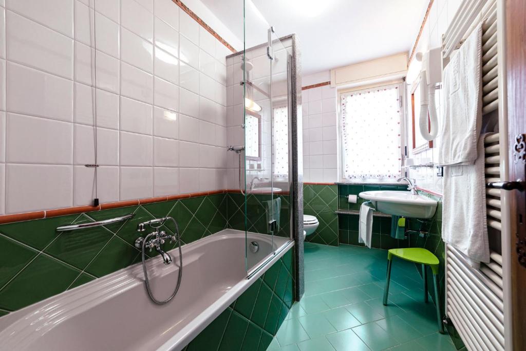 a bathroom with a tub and a sink at Hotel Bouton d'Or - Courmayeur in Courmayeur
