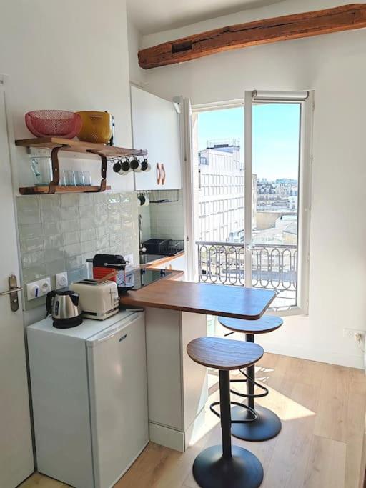 - une cuisine avec une table et deux tabourets dans l'établissement La Cabane Parisienne - Au centre de Paris - Lumineux - Vue panoramique, à Paris