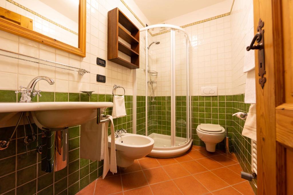 a bathroom with a sink and a toilet and a shower at Hotel Bouton d'Or - Courmayeur in Courmayeur