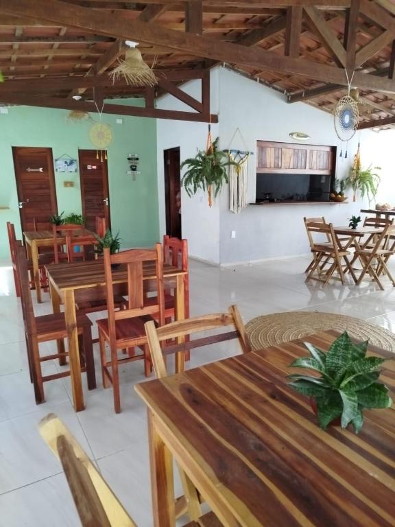 a dining room with wooden tables and chairs at Pitico - Pousada Icaraí Kite Village in Icaraí