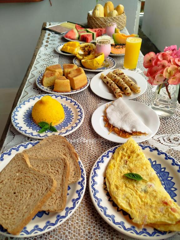 a table with plates of breakfast food on it at Pitico - Pousada Icaraí Kite Village in Icaraí