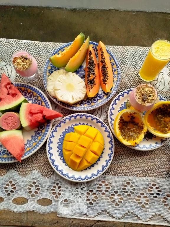 a table with four plates of fruit on them at Pitico - Pousada Icaraí Kite Village in Icaraí