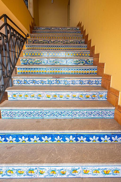 a set of stairs with blue and white tiles at Baia Taormina - CDSHotels in Forza dʼAgro