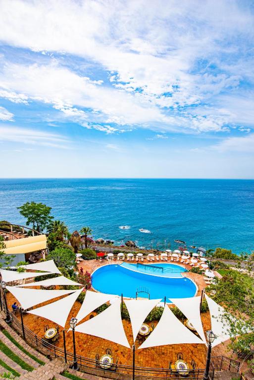 an aerial view of a resort with a swimming pool and the ocean at Baia Taormina - CDSHotels in Forza dʼAgro