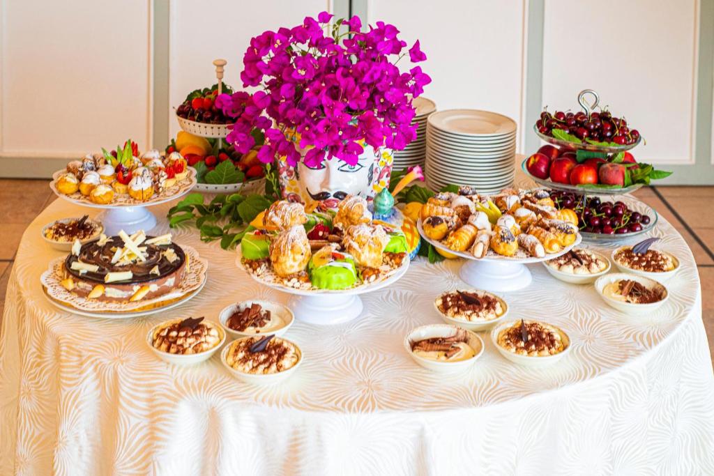 a table topped with appetizers and plates of food at Baia Taormina - CDSHotels in Forza dʼAgro