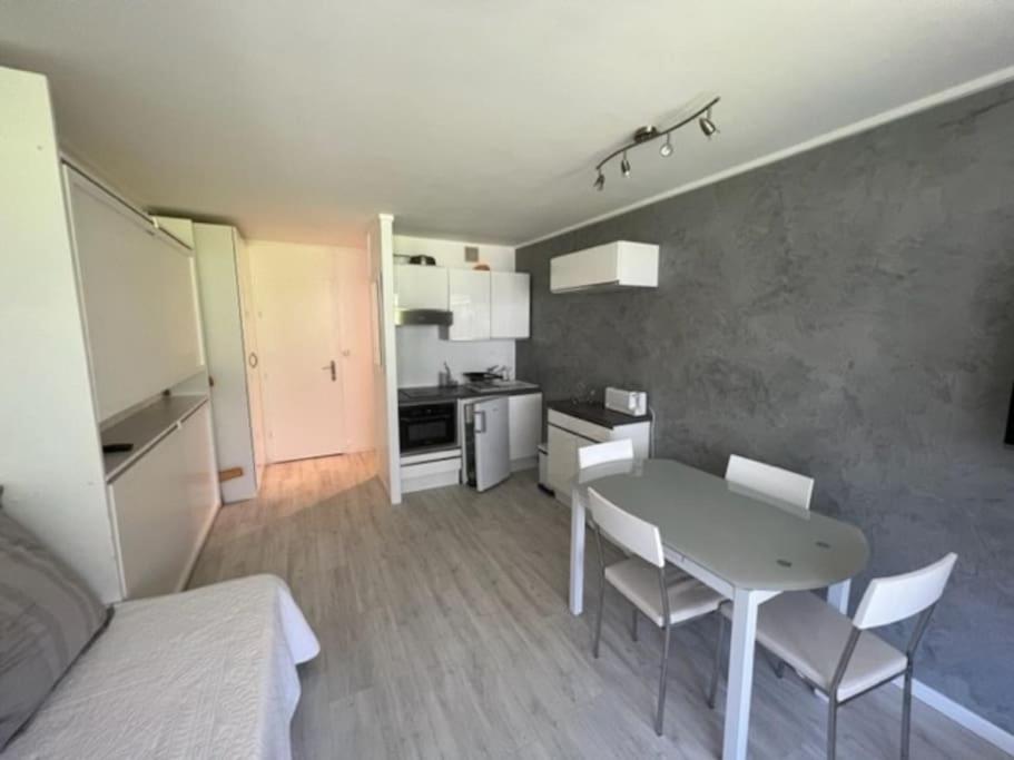 une cuisine et une salle à manger avec une table et des chaises dans l'établissement Superbe studio 4 pers skis aux pieds avec balcon, à Tignes