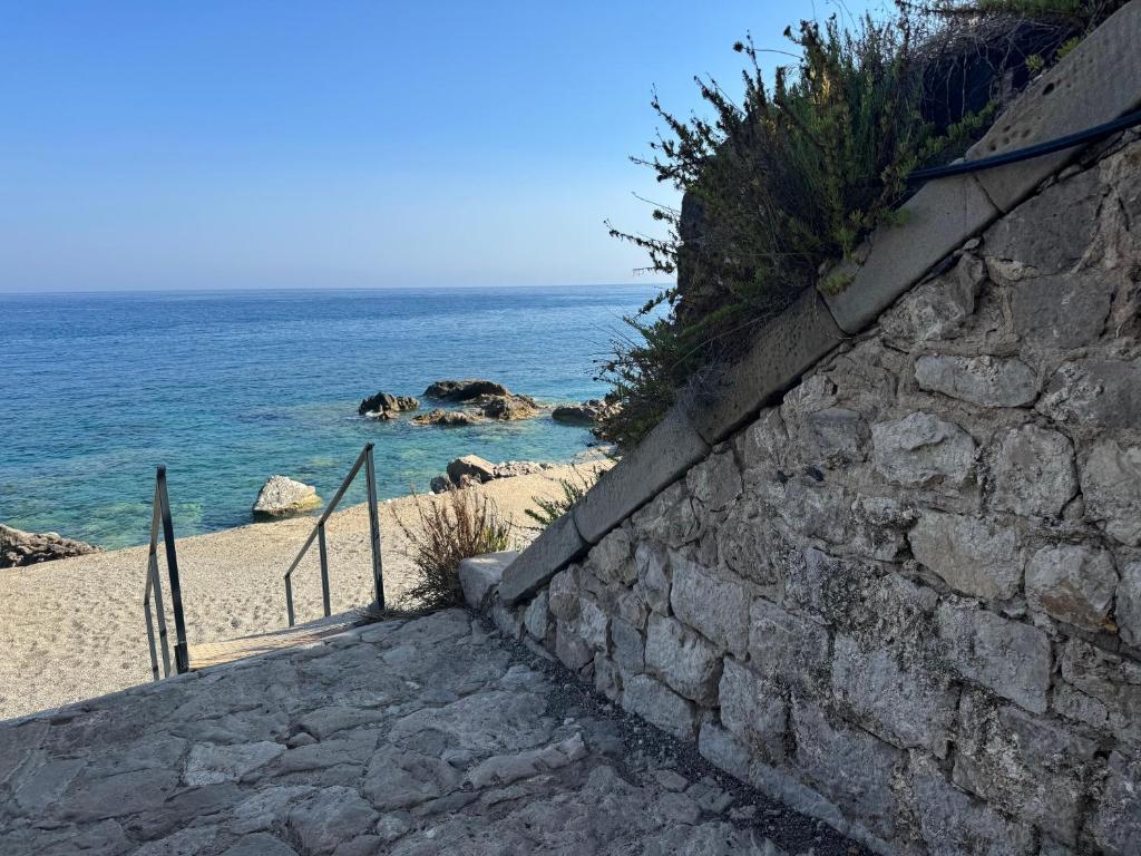 a stone staircase leading to a beach with the ocean at Baia Taormina - CDSHotels in Forza dʼAgro