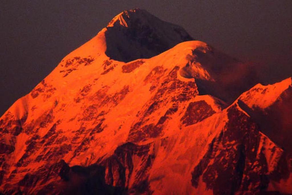 a mountain with an orange light on it at Snow View Guest House Kausani & homestay in Kausani