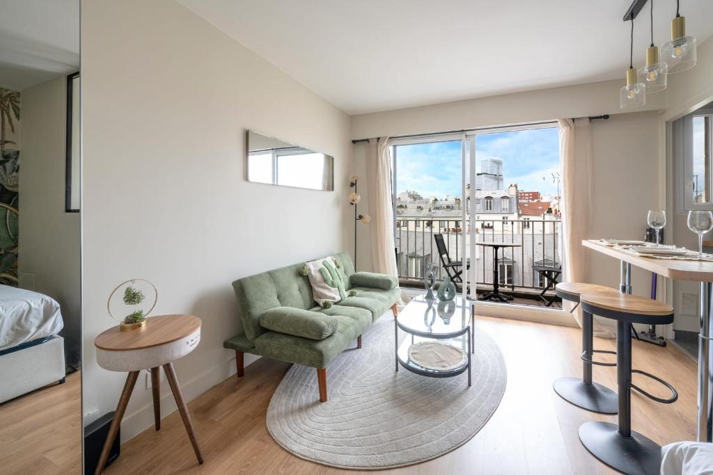 un salon avec un canapé et une table dans l'établissement Studio avec balcon - Paris 17e, à Paris