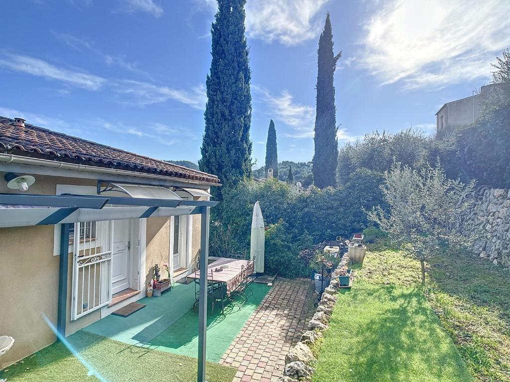 une maison avec un parasol et une cour avec des arbres dans l'établissement Campagne en ville Villa T3 75m2 Jardin 60m2, à Auriol