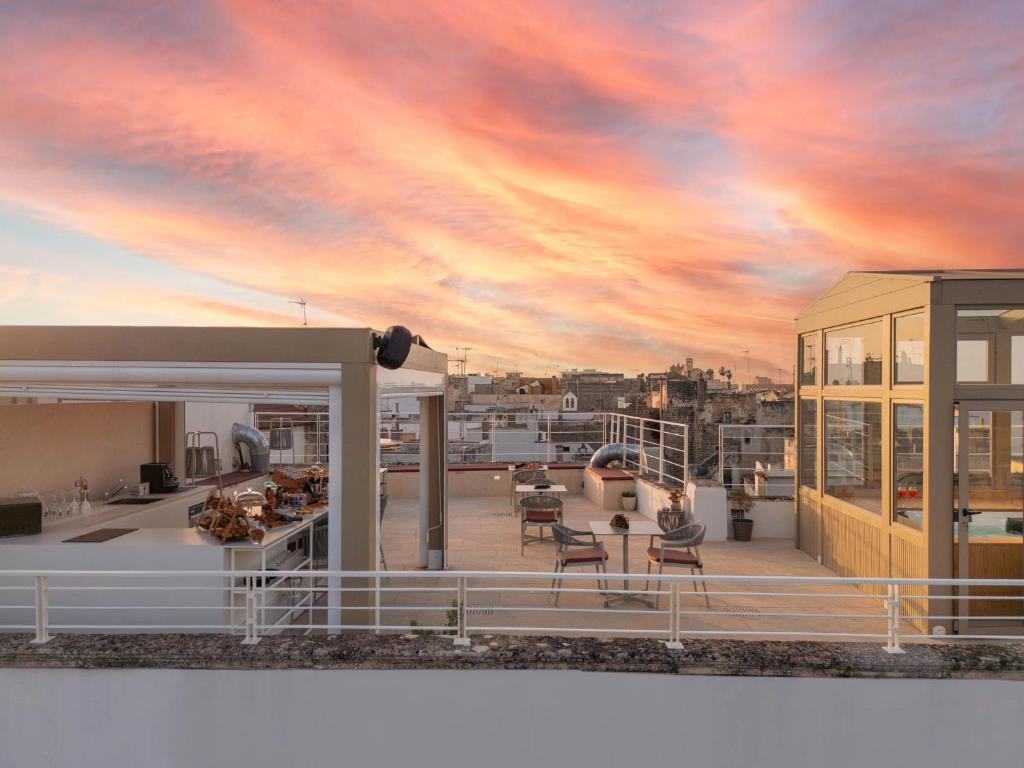 a rendering of a rooftop deck with a sunset at Palazzo Arco Cadura Hotel & Spa in Galatina