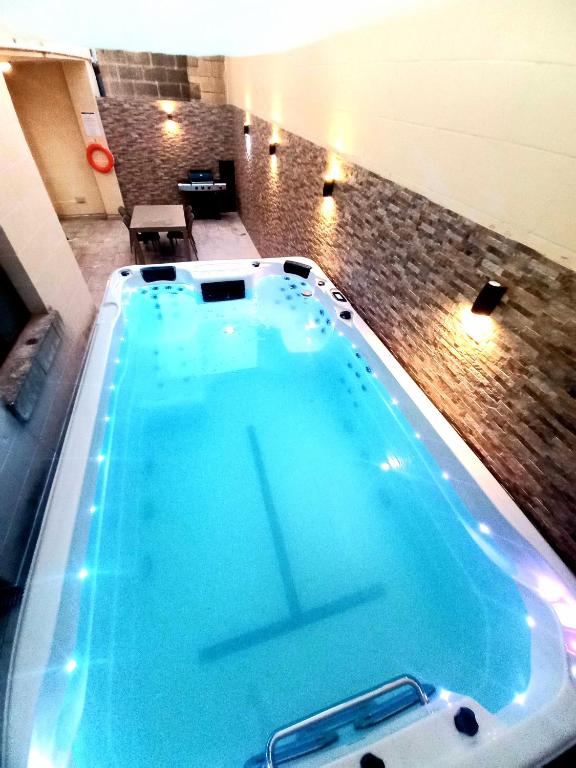 duży basen z błękitną wodą w pokoju w obiekcie Luxurious apartment with heated pool jacuzzi w mieście Fontana