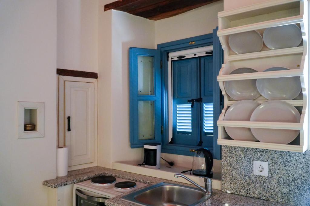 eine Küche mit einem Waschbecken und einem blauen Schrank in der Unterkunft Symi Uptown Carmine in Symi