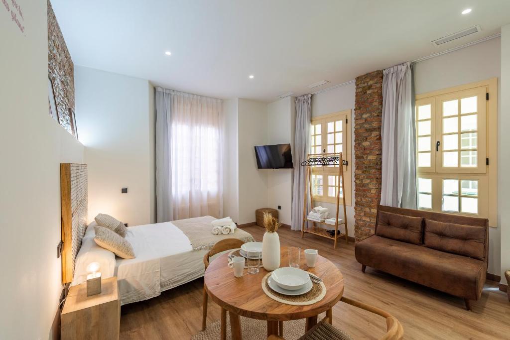 una sala de estar con una cama y una mesa en iloftmalaga Pasaje Chinitas, en Málaga