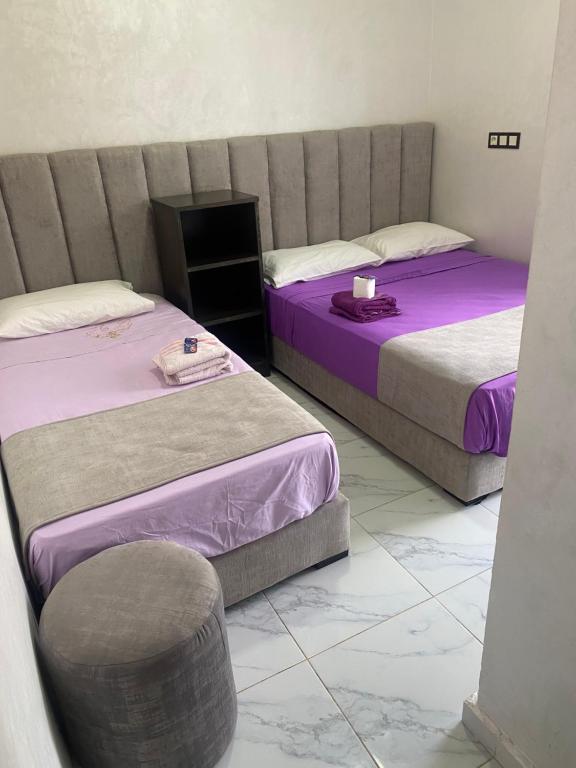 纳祖尔Hotel al andalus N4的有两张床和一把椅子的房间