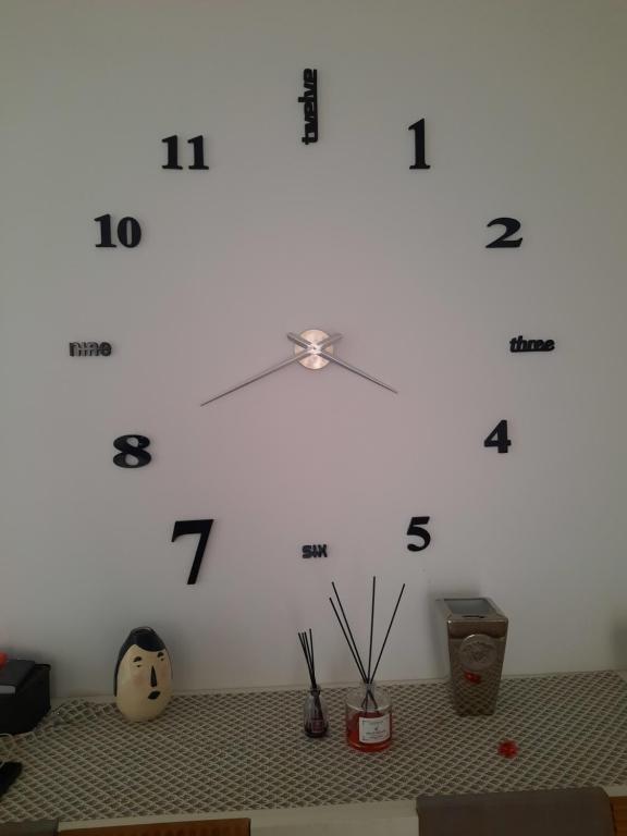 Un gran reloj blanco en una pared blanca en Il filo di Arianna, en Putignano