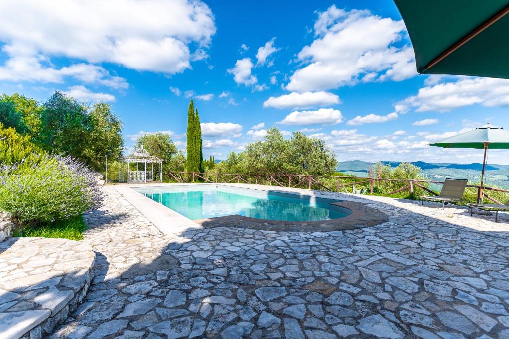 a swimming pool with a patio and an umbrella at Bellaria Apartments - Chianti View, Swimming Pool, Nature in San Sano