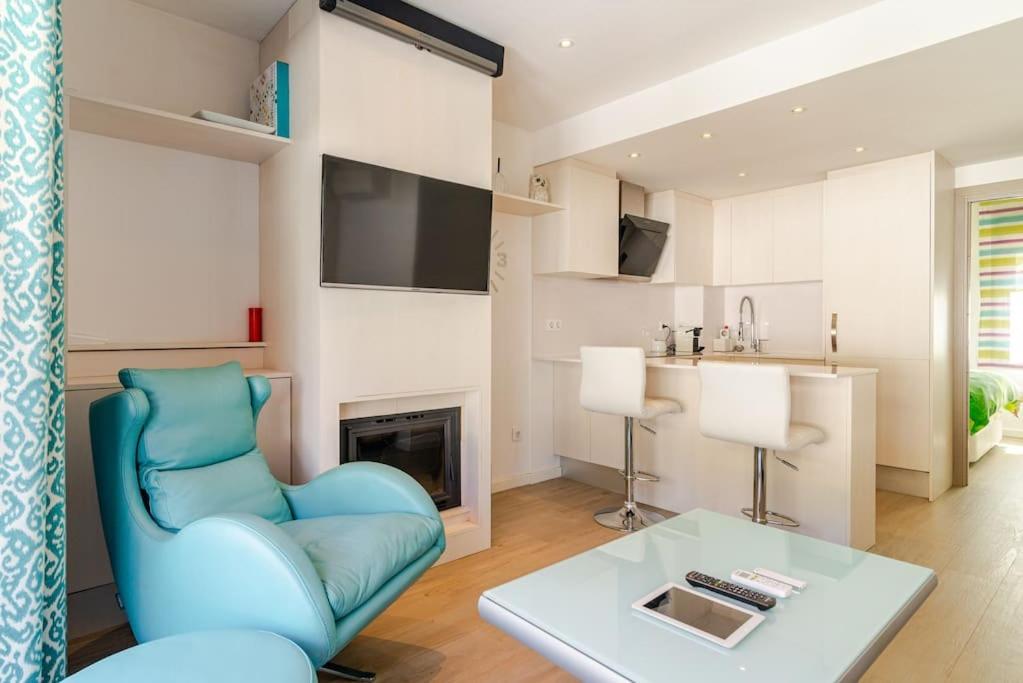 un salon avec une chaise bleue et une table dans l'établissement Piso reformado a pie de playa Sa Riera Begur, à Begur