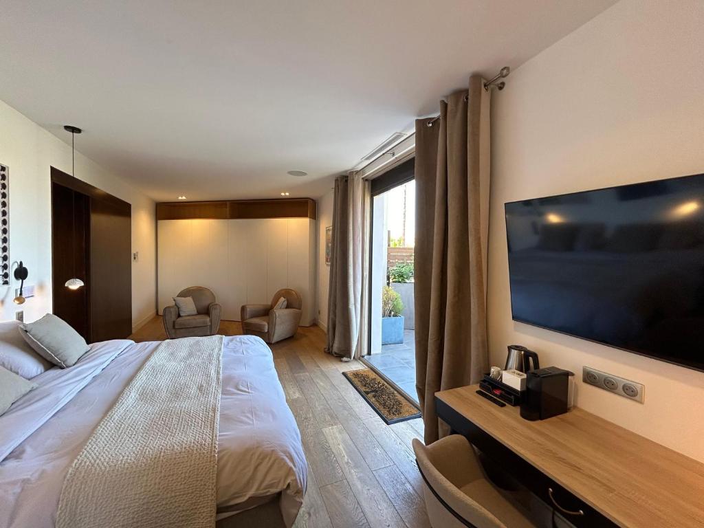 a hotel room with a large bed and a tv at Maï Homes - La Villa Bompard in Marseille
