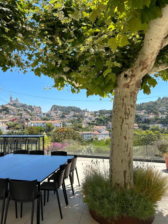 a table and chairs under a tree on a patio at Maï Homes - La Villa Bompard in Marseille