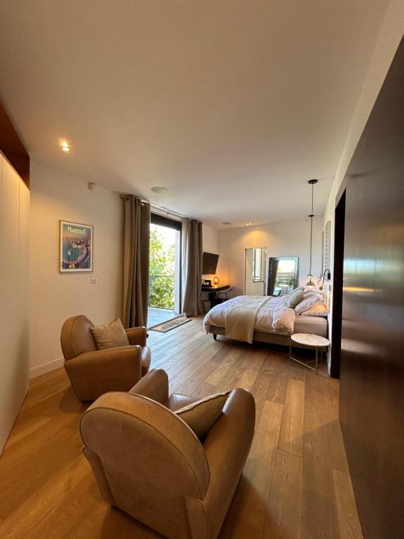 a bedroom with a bed and a couch and a chair at Maï Homes - La Villa Bompard in Marseille