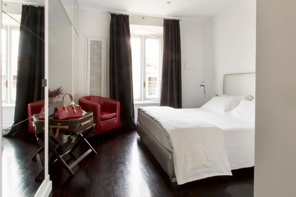 a bedroom with a bed and a red chair at Xenia Guest House in Rome