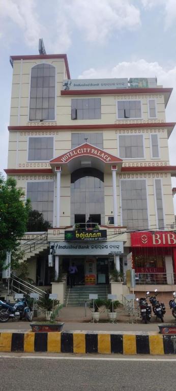 a large building with motorcycles parked in front of it at Hotel City Palace in Brahmapur