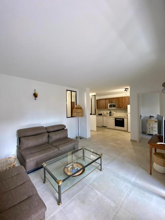 un salon avec un canapé et une table en verre dans l'établissement 2 pièces lumineux à Cagnes sur mer, à Cagnes-sur-Mer