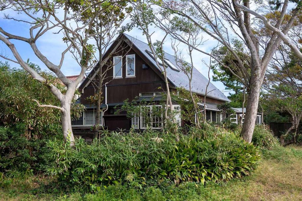 叶山町Hayama Isshiki Beach House -葉山 一色海岸の家 - ペット可的前面有树木的棕色房子
