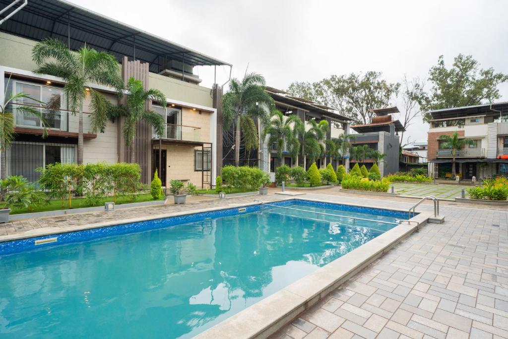 ロナバラにあるAlaya Stays - Imperial Mystara 5BHK near Khandala Hillsの建物の前のプール