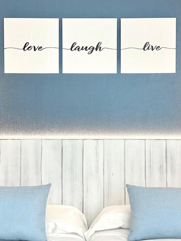 a bed with four pieces of paper with the words love myself at Nerja Casual Rooms in Nerja