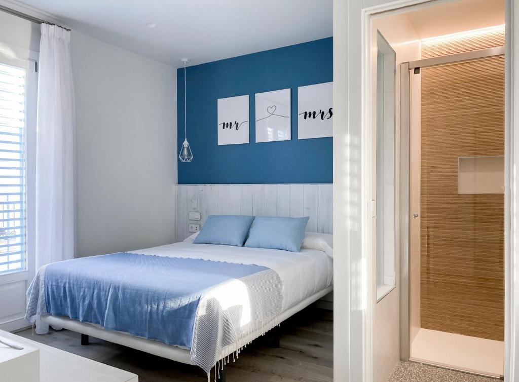 a bedroom with a bed with blue walls and a door at Nerja Casual Rooms in Nerja