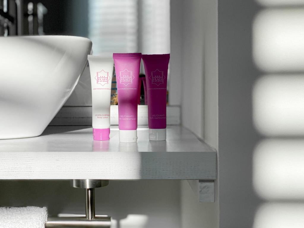 a shelf with three tubes of pink and white products at Nerja Casual Rooms in Nerja