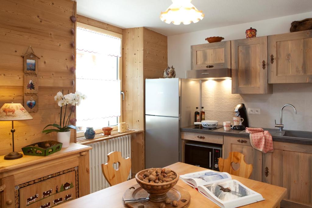 a kitchen with a refrigerator and a table at Appartement Zian Justine in Lullin