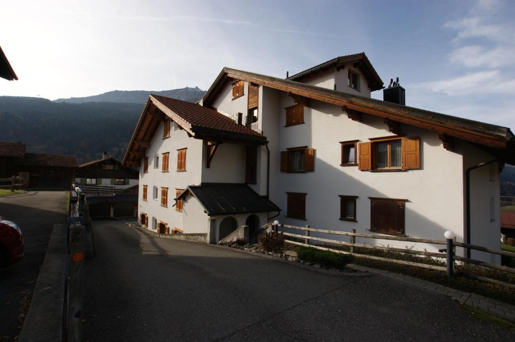 un edificio bianco con finestre in legno su una strada di Gotschnablick a Klosters