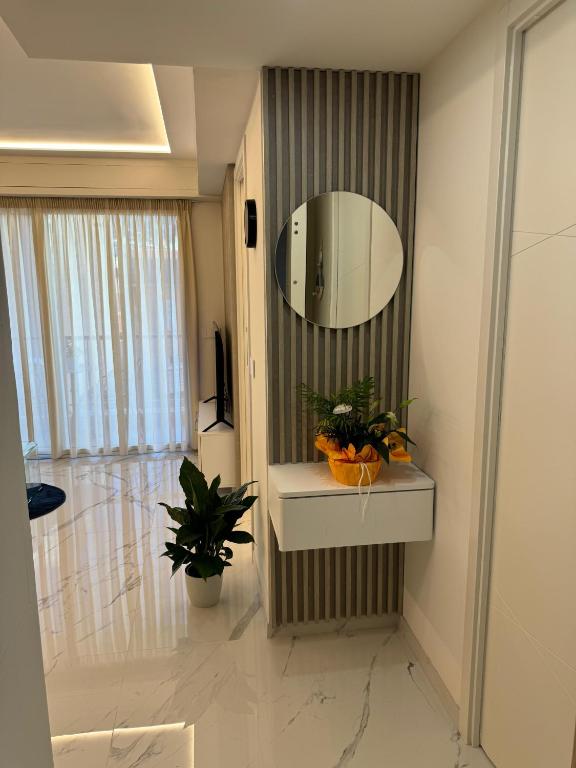 une salle de bain avec un lavabo et un miroir au mur dans l'établissement Residence du Casino, à Menton