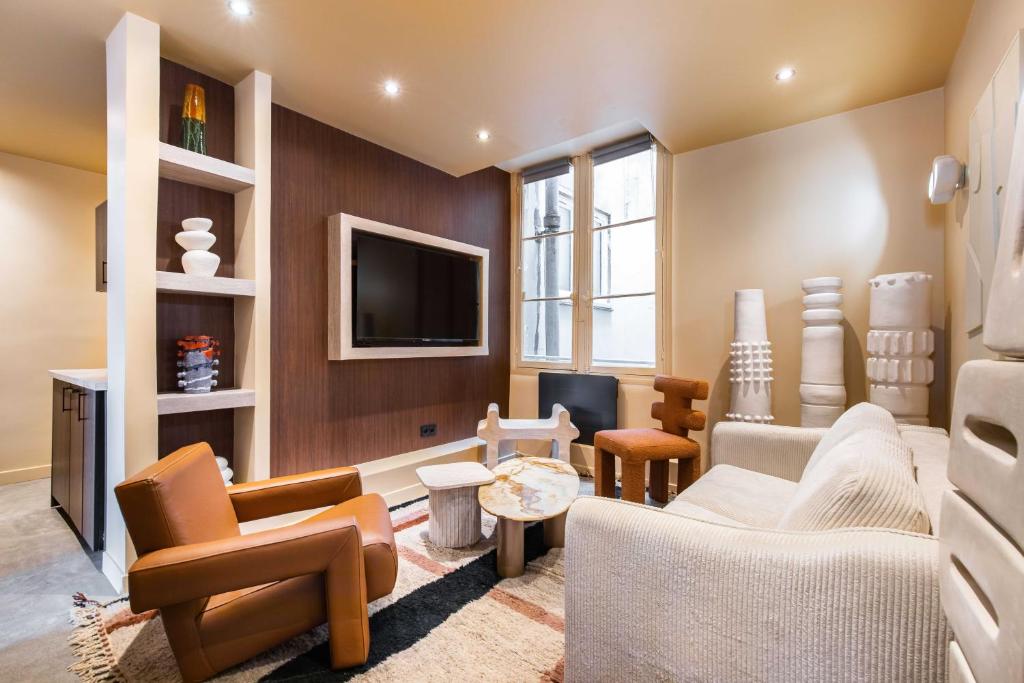 un salon rempli de meubles et d'une télévision à écran plat dans l'établissement Gorgeous apartment - 2BR-8P - Le Marais, à Paris