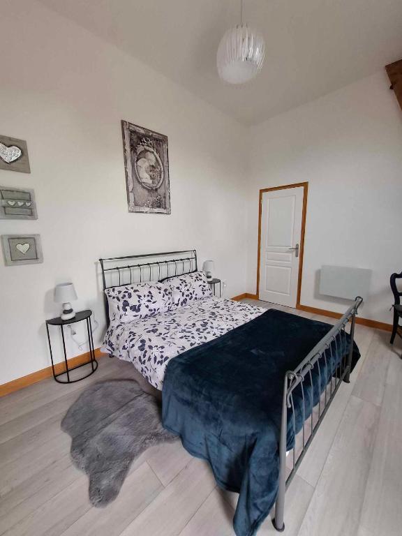 a bedroom with a bed with a blue blanket on it at Perfect Gites In Normandy - New Beginnings Barn in Saint-Sauveur-de-Chaulieu
