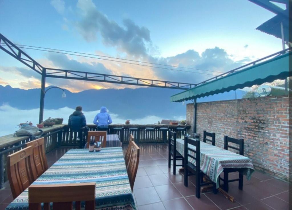 two people sitting at a table on a patio at Daun Pisang Homestay & Halal Food in Sapa