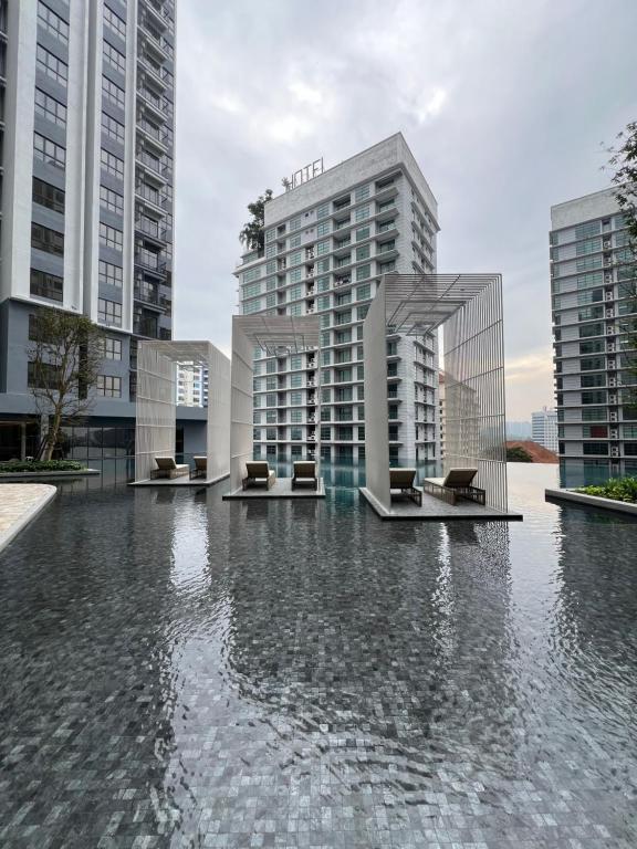 a pool of water with two tall buildings at SY Urban Dwell Staycation Near Shah Alam Stadium in Shah Alam