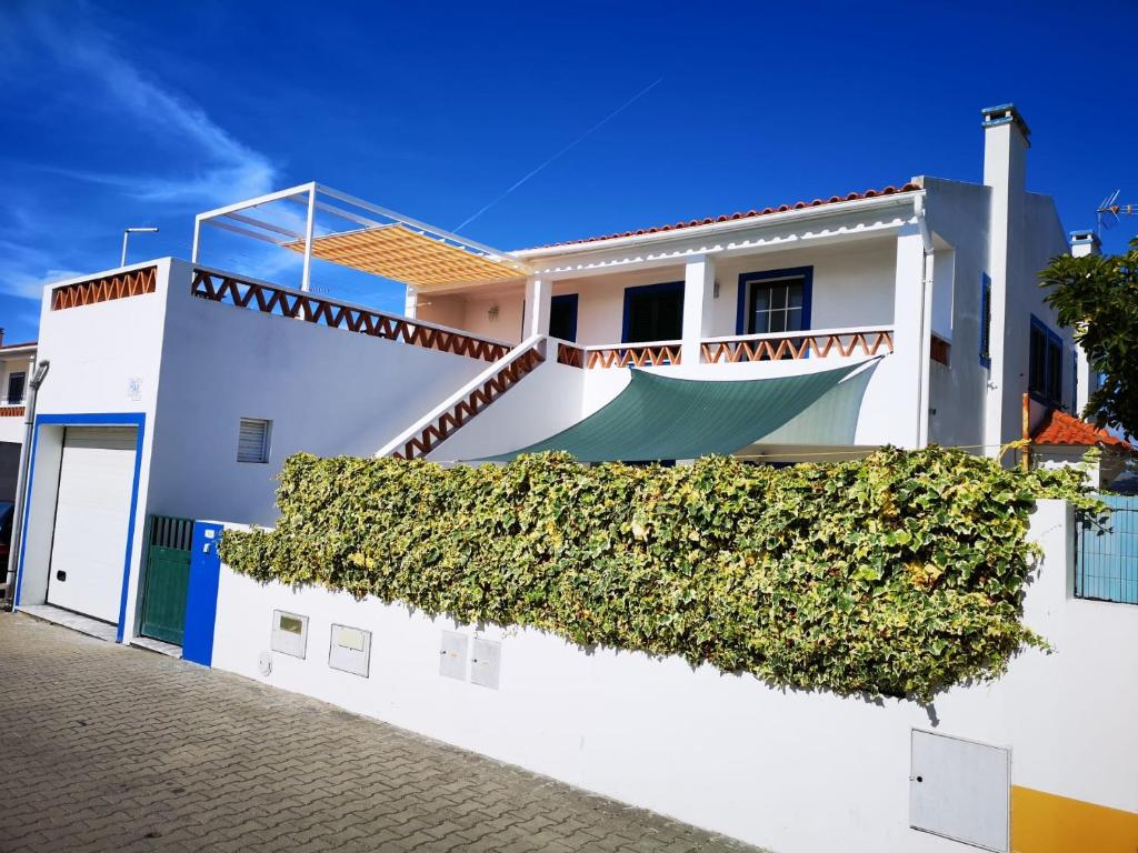 una casa bianca con l'edera verde sopra di Casa Lagoa Mar a Costa de Santo André