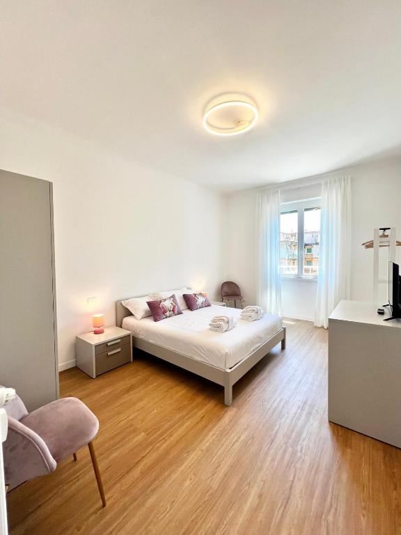 a white bedroom with a bed and a window at Doria home-Saint Peter's View in Rome
