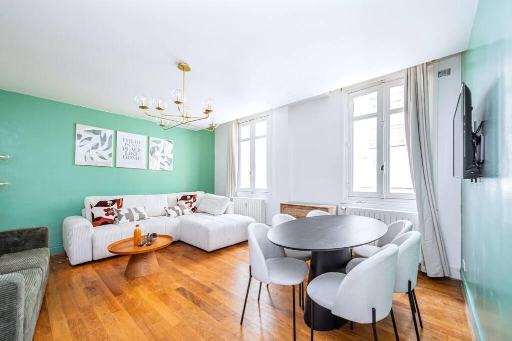 un salon avec un canapé blanc et une table dans l'établissement Appartement Plein Pied cœur de Neuilly-sur-seine, à Neuilly-sur-Seine