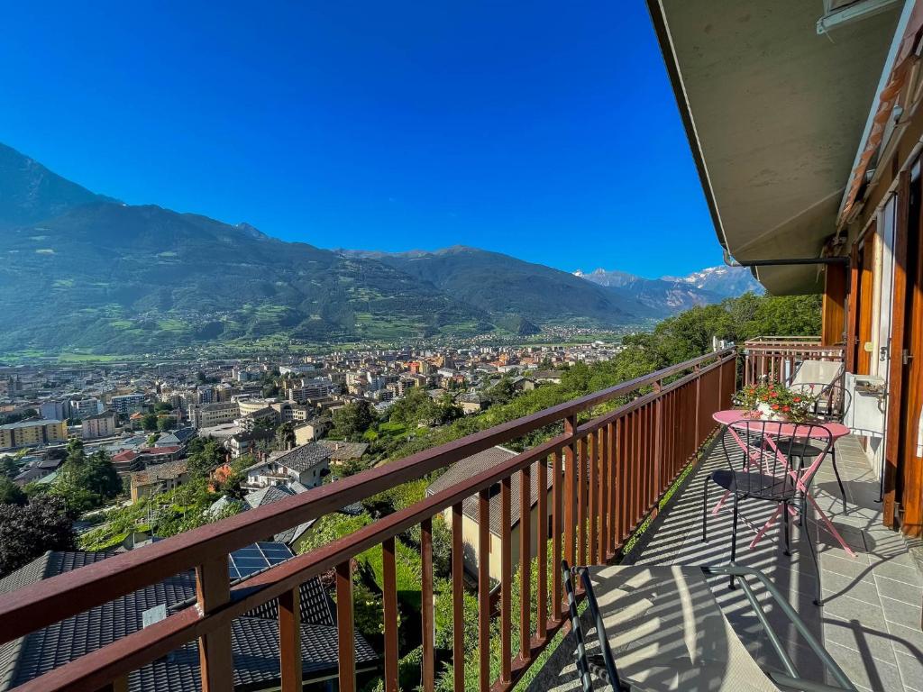un balcon avec une table et une vue sur une ville dans l'établissement L'Atelier du Temps - BellAosta Home, à Aoste